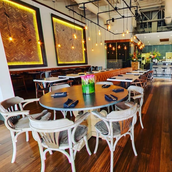 The Sea South East Asian Kitchen and Sushi dining room with tables, chairs, and illuminated wall art.